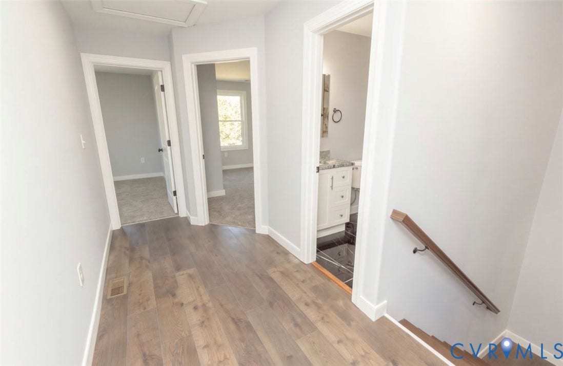 25604 Greensville Avenue, West Petersburg, Dinwiddie, VA 23803 Hallway featuring wood-finish flooring, neutral wall tones, and a staircase with a wooden handrail