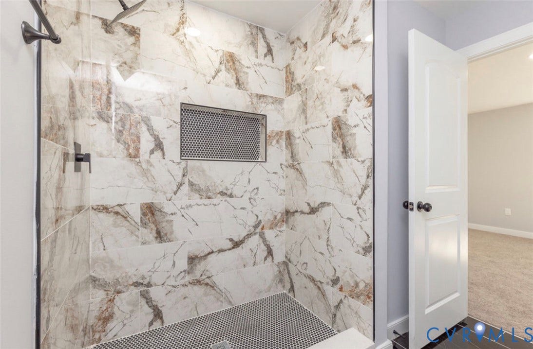 25604 Greensville Avenue, West Petersburg, Dinwiddie, VA 23803 Walk-in shower featuring large-format patterned tile, mosaic-tiled floor, built-in tiled niche, and matte black plumbing fixtures