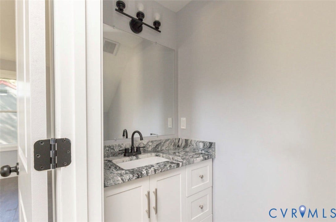 25604 Greensville Avenue, West Petersburg, Dinwiddie, VA 23803 Bathroom vanity featuring a stone countertop, white cabinetry, a rectangular undermount sink, a matte black faucet, and a coordinating three-light vanity fixture