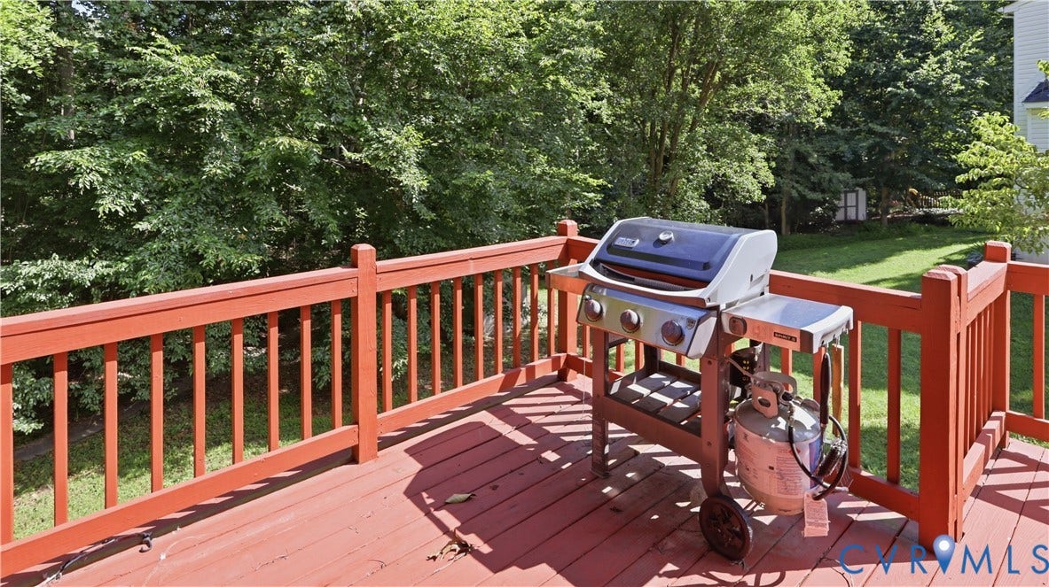 10208 Claybar Trail, Chesterfield, VA 23236 Raised wooden deck featuring vertical baluster railings and a grassy yard backdrop