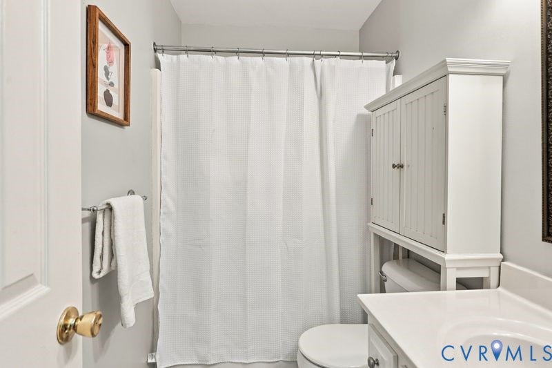 10208 Claybar Trail, Chesterfield, VA 23236 Bathroom featuring a vanity with integrated sink, over-the-toilet beadboard cabinetry, and a shower-tub combination with a metal tension rod