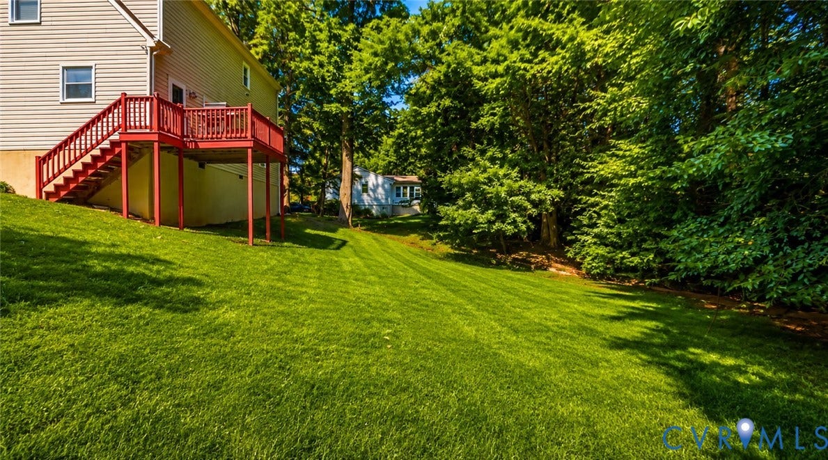 10208 Claybar Trail, Chesterfield, VA 23236 Expansive backyard featuring a tiered wooden deck with railing, sloping lawn, and perimeter mature trees