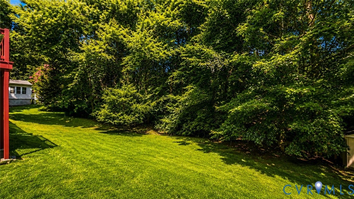 10208 Claybar Trail, Chesterfield, VA 23236 Expansive backyard featuring a manicured lawn, perimeter of mature trees, and an attached red deck structure