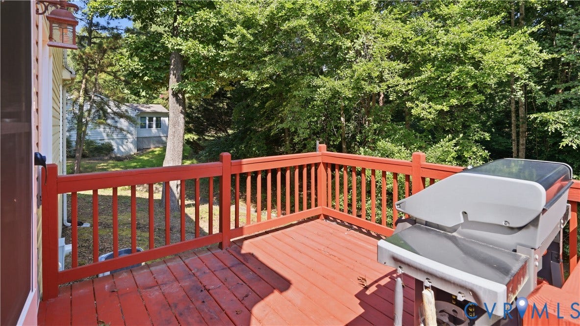 10208 Claybar Trail, Chesterfield, VA 23236 Raised outdoor deck featuring painted wood decking, matching picket railings, and an attached exterior wall-mounted light fixture