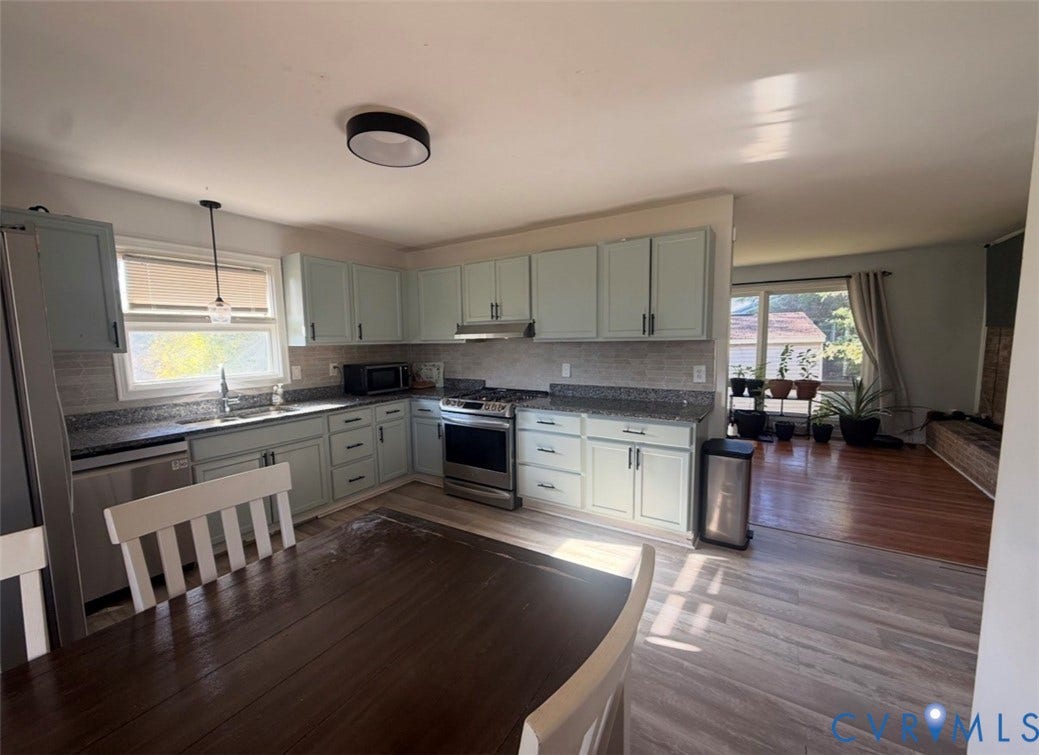 Kitchen featuring light-toned cabinetry, stone-finish countertops, stainless steel appliances, a tile backsplash, and recessed ceiling lighting