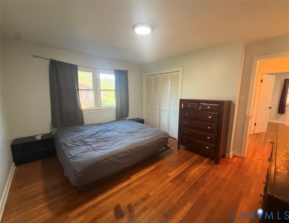 Hardwood flooring, dual-pane windows, and white louvered closet doors