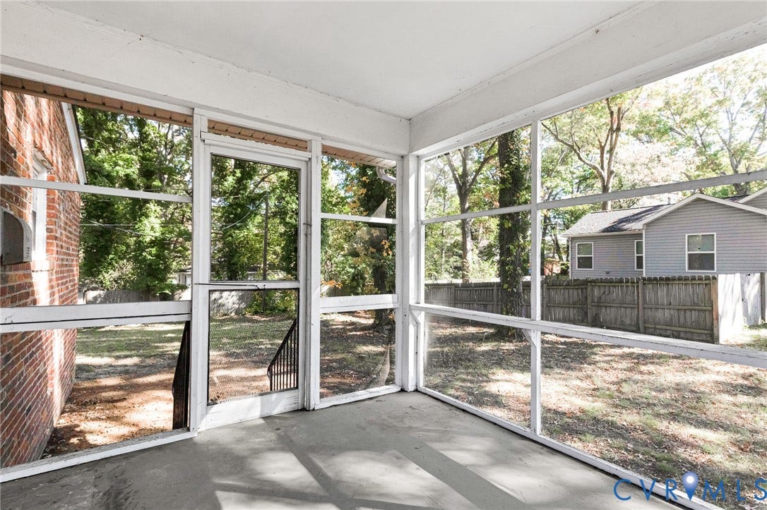 7304 Bowler Street, Henrico, VA 23228 Screened-in porch featuring full-height window panels, a metal-framed storm door, concrete flooring, and an exterior brick wall