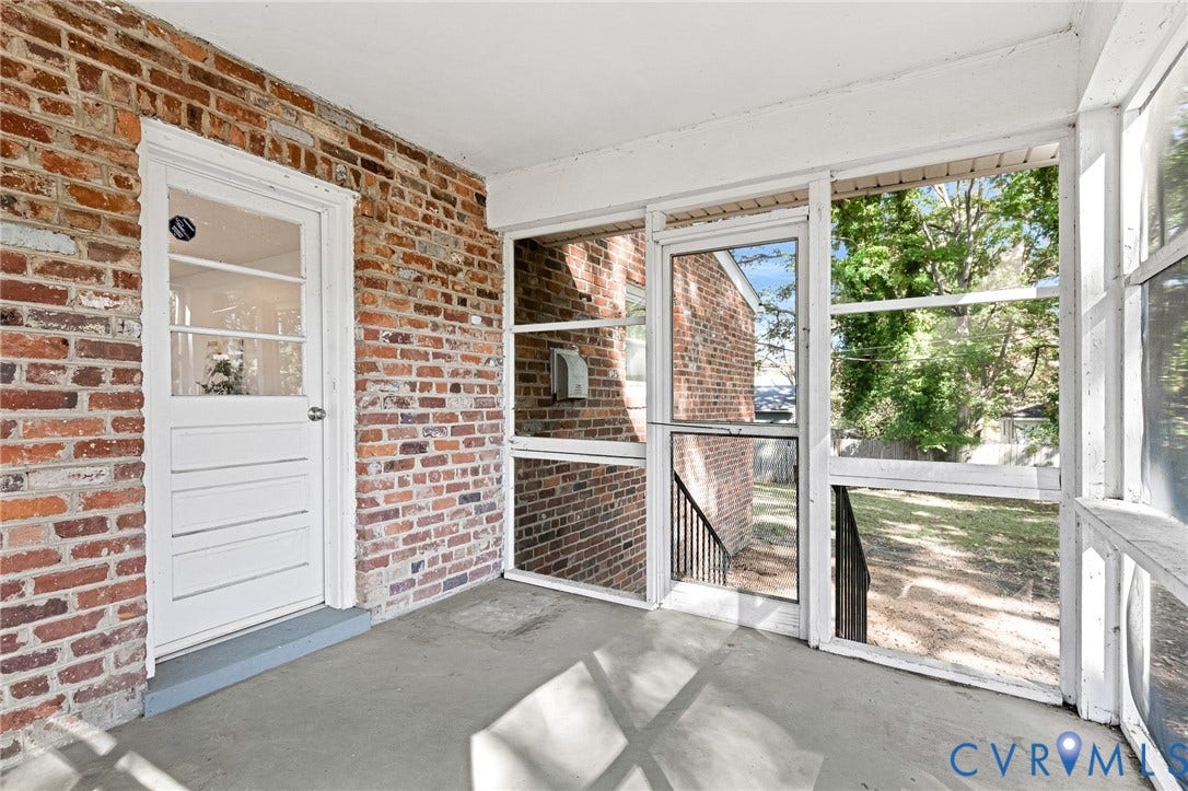 7304 Bowler Street, Henrico, VA 23228 Screened-in porch featuring exposed red brick walls, concrete flooring, and a white-framed glass pane door