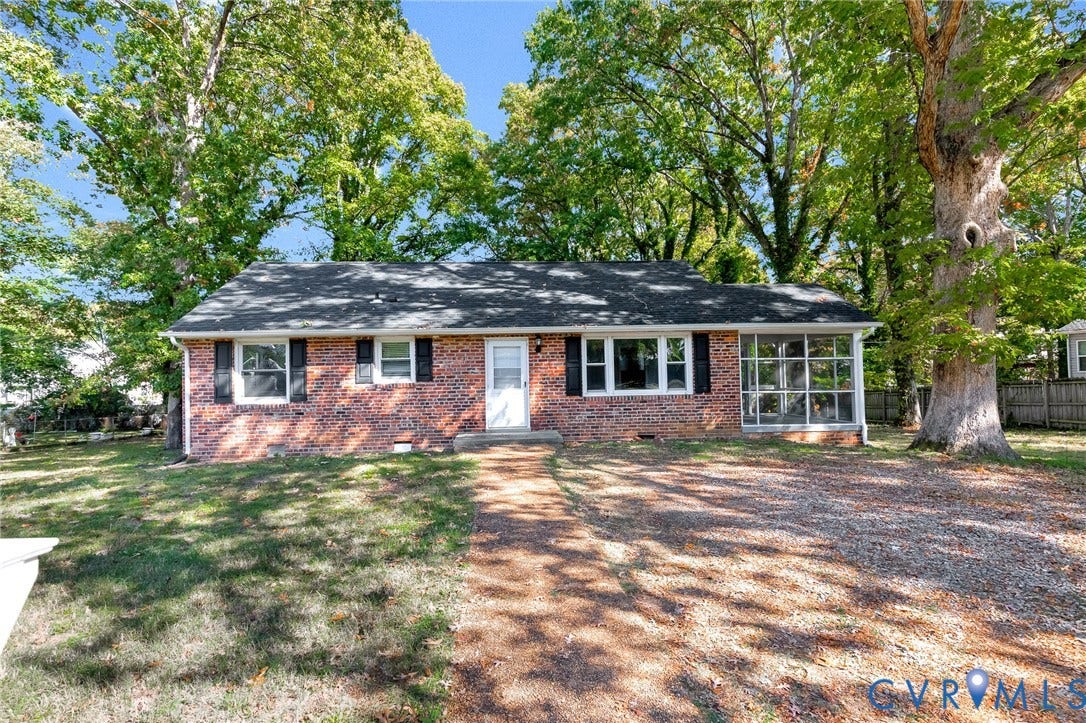 7304 Bowler Street, Henrico, VA 23228 Brick exterior residence featuring a front-facing screened porch, dark window shutters, and a gravel driveway