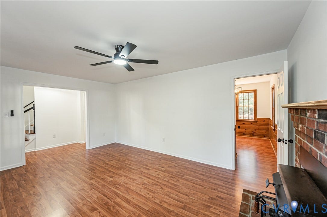 10100 Brittonwood Drive, Chesterfield, VA 23237 Interior space featuring wood-finish flooring, a ceiling fan with integrated lighting, and a brick fireplace hearth
