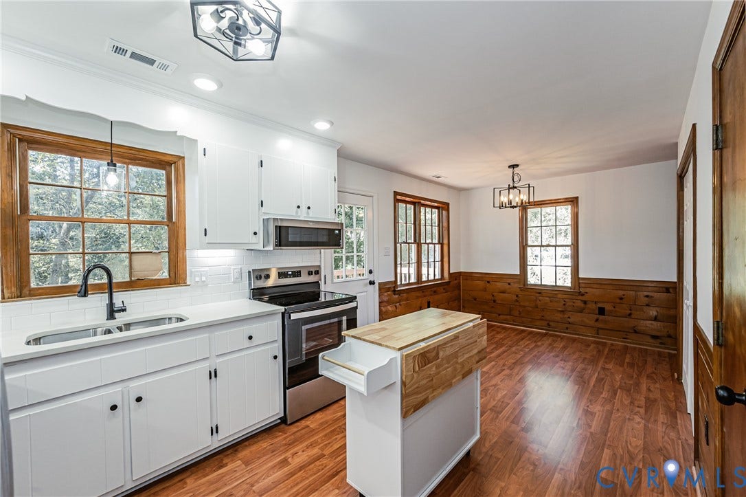 10100 Brittonwood Drive, Chesterfield, VA 23237 Kitchen featuring white cabinetry, subway tile backsplash, wood-finish flooring, stainless steel appliances, and wood-paneled walls