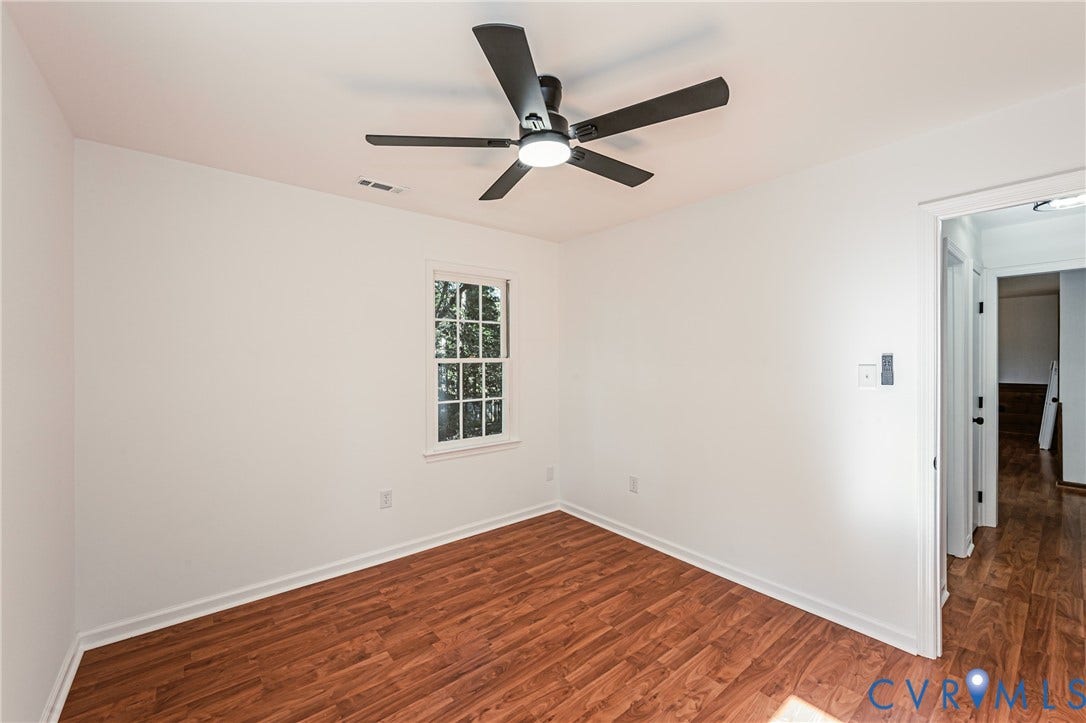 10100 Brittonwood Drive, Chesterfield, VA 23237 Room featuring wood-finish flooring, a multi-blade ceiling fan with integrated lighting, and a single-pane window with grid muntins