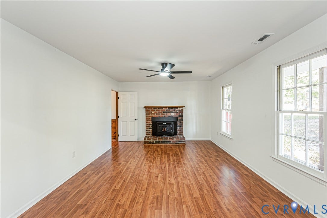 10100 Brittonwood Drive, Chesterfield, VA 23237 Interior space featuring wood-finish flooring, a red-brick fireplace, a wooden mantel, and a ceiling-mounted light fixture with a fan