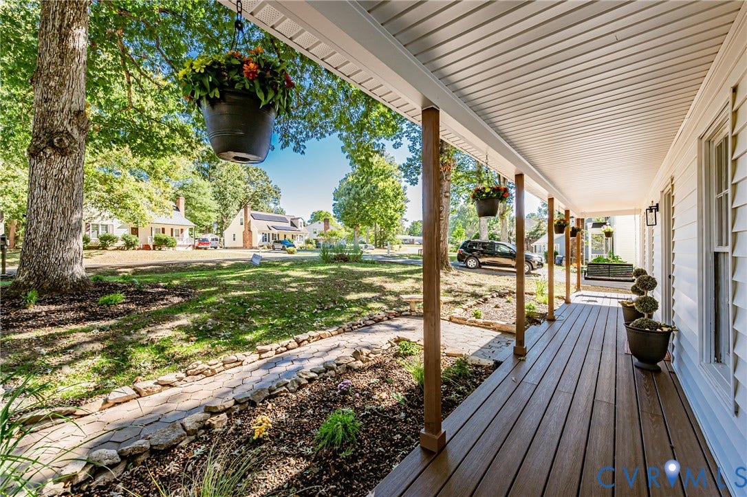 10100 Brittonwood Drive, Chesterfield, VA 23237 Covered front porch featuring wood-finish decking, horizontal siding, and natural stone border hardscaping