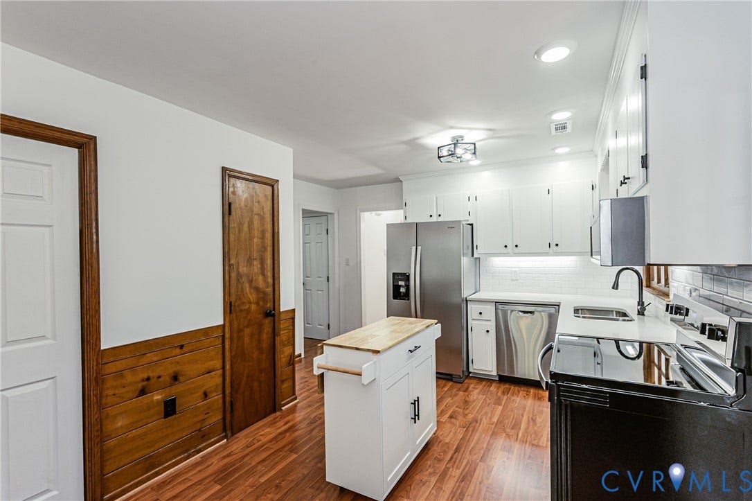 10100 Brittonwood Drive, Chesterfield, VA 23237 Kitchen featuring white shaker-style cabinetry, stainless steel appliances, wood-finish flooring, and natural wood wainscoting