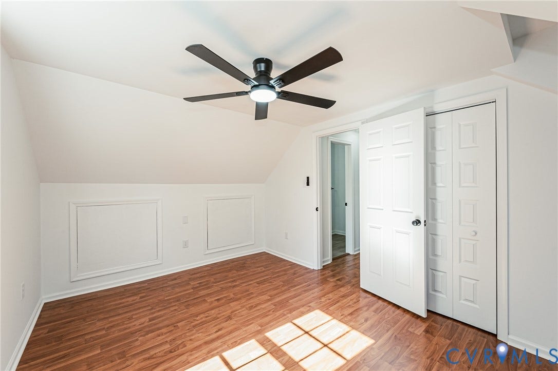 10100 Brittonwood Drive, Chesterfield, VA 23237 Room featuring wood-finish flooring, a matte black ceiling fan with integrated lighting, dual wall access panels, and white six-panel interior doors