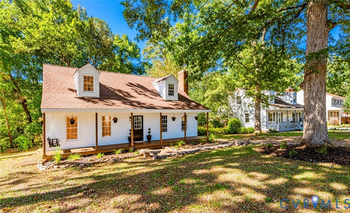 10100 Brittonwood Drive, Chesterfield, VA 23237 Cape Cod-style residence featuring a white lap siding exterior, two front dormers, a covered front porch, and a stone-lined landscaping bed