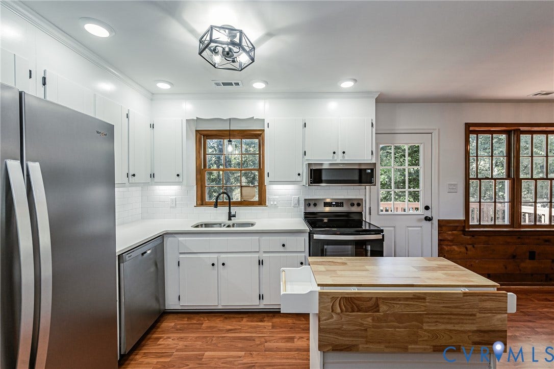 10100 Brittonwood Drive, Chesterfield, VA 23237 Kitchen featuring white shaker-style cabinetry, stainless steel appliances, subway tile backsplash, wood-finish flooring, and a central island with a wood-block surface