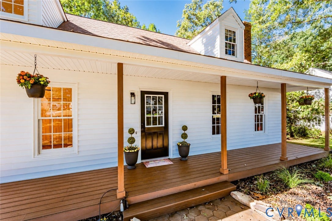 10100 Brittonwood Drive, Chesterfield, VA 23237 Exterior facade featuring white horizontal siding, a covered front porch with wood-finish decking, dark-toned entry door with grid-pane glass, and roof dormers