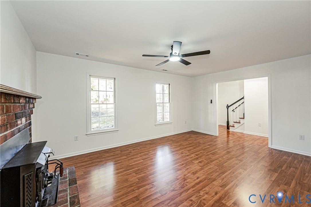 10100 Brittonwood Drive, Chesterfield, VA 23237 Living area featuring wood-finish flooring, a brick fireplace with a metal insert, multi-pane windows, and a ceiling fan
