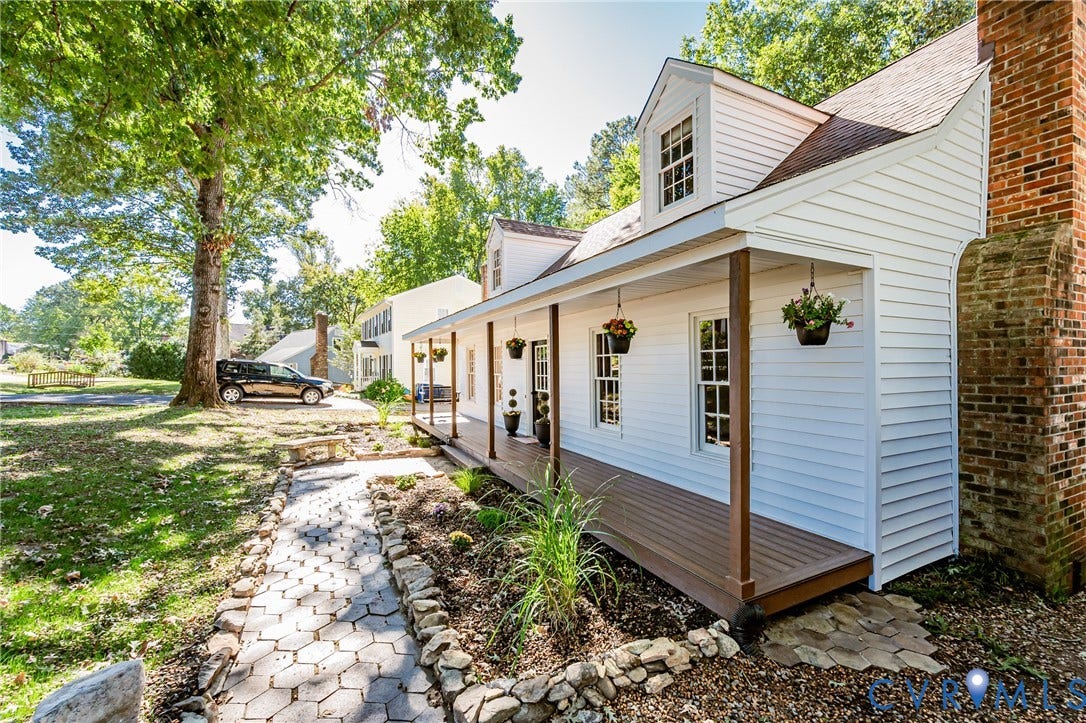 10100 Brittonwood Drive, Chesterfield, VA 23237 Exterior featuring white siding, a wraparound covered porch with wood-finish decking, two dormer windows, and a prominent brick chimney