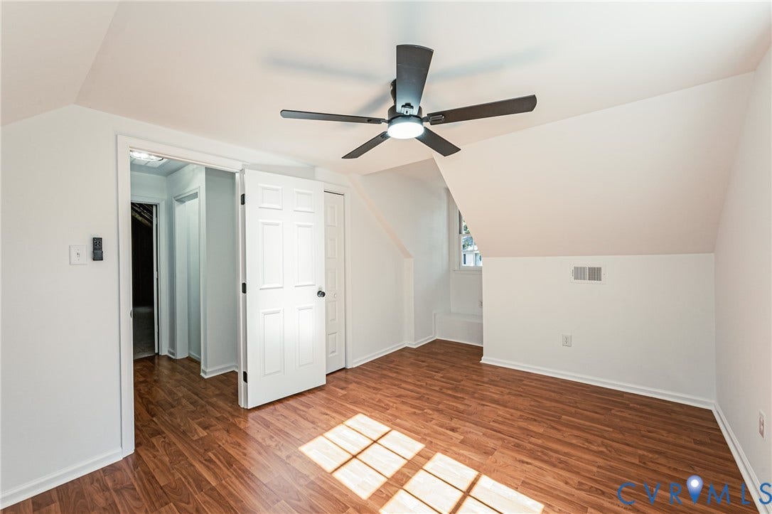 10100 Brittonwood Drive, Chesterfield, VA 23237 Room featuring sloped ceilings, wood-finish flooring, a six-panel interior door, and a central ceiling fan with integrated lighting
