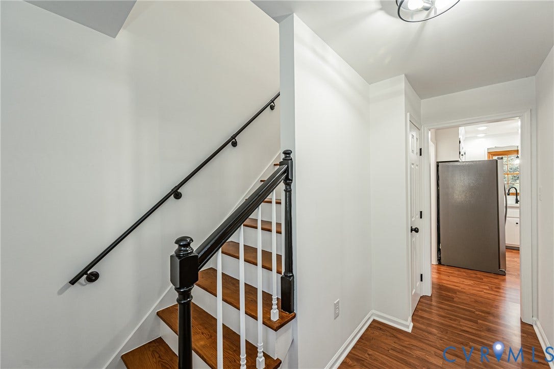 10100 Brittonwood Drive, Chesterfield, VA 23237 Staircase featuring wood-finish treads, white balusters, and a black-finish handrail