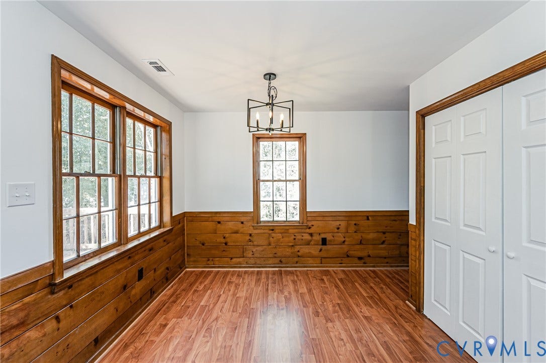 10100 Brittonwood Drive, Chesterfield, VA 23237 Wood-finish flooring, half-height wood paneling, multi-pane windows with wood trim, six-panel closet doors, and geometric metal chandelier