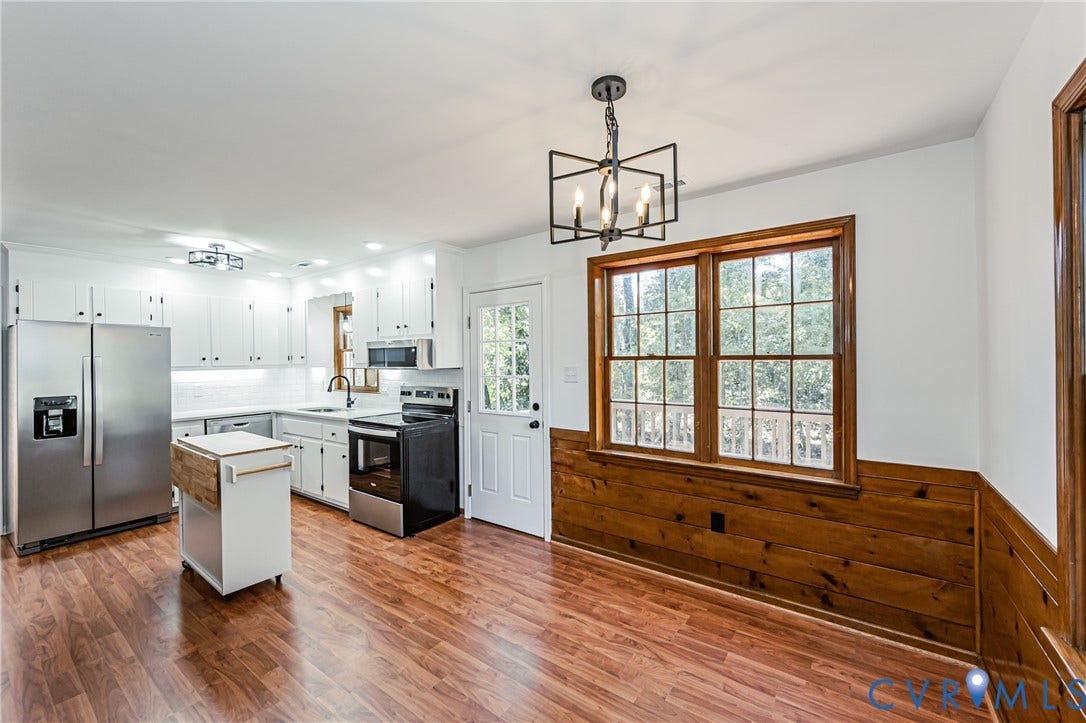 10100 Brittonwood Drive, Chesterfield, VA 23237 Kitchen featuring white shaker cabinetry, stainless steel appliances, wood-finish flooring, half-wall wood paneling, and a geometric-style metal chandelier