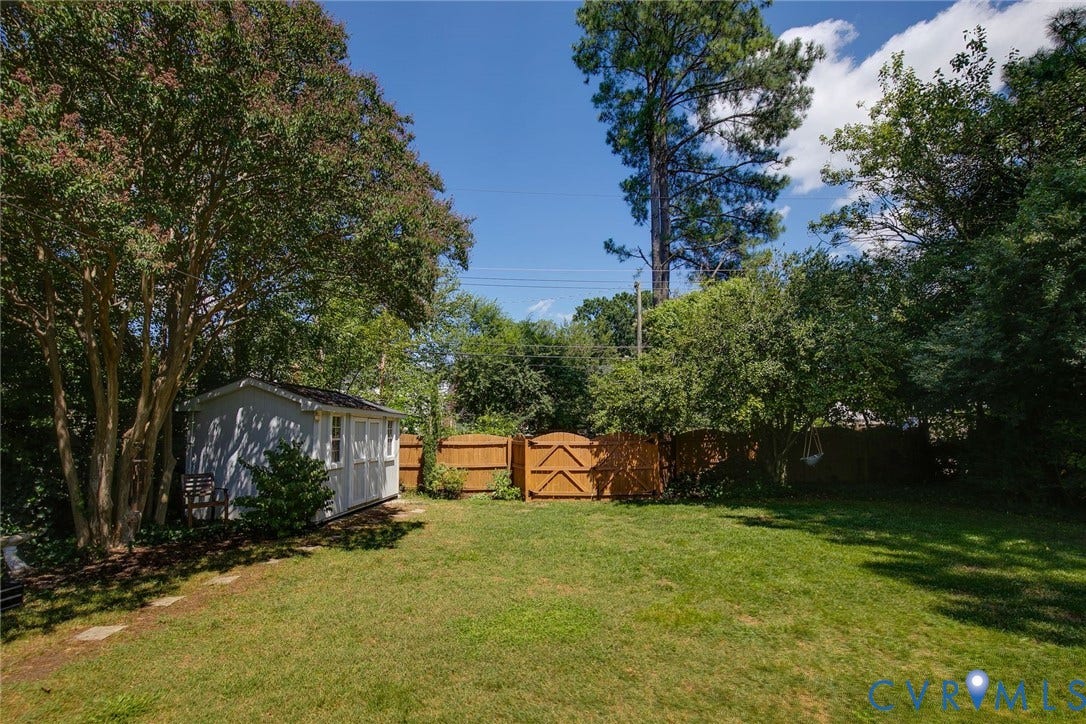 4710 Park Avenue, Mary Munford / Near West End, Richmond, VA 23226 Backyard featuring a grass lawn, wooden privacy fencing, detached storage structure, and mature trees