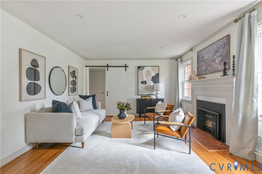 4710 Park Avenue, Mary Munford / Near West End, Richmond, VA 23226 Living area featuring wood-finish flooring, a fireplace with a decorative mantel and terracotta-toned hearth, and a sliding door with black iron hardware