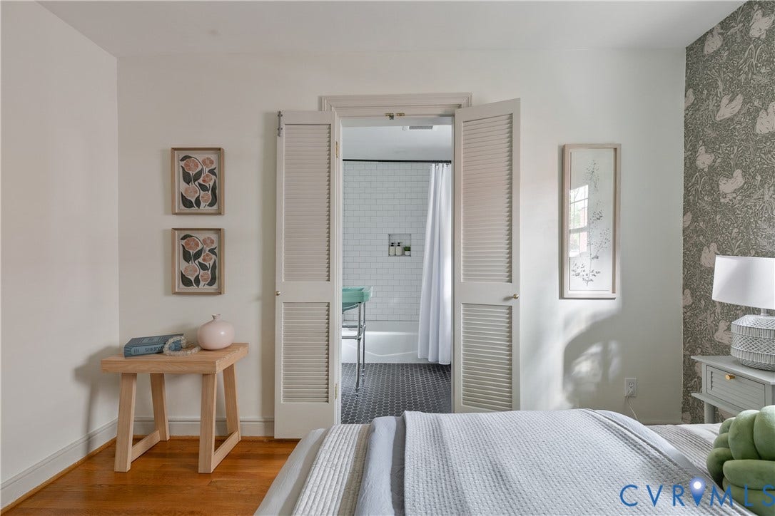 4710 Park Avenue, Mary Munford / Near West End, Richmond, VA 23226 Wood-finish flooring, patterned accent wall covering, and white bi-fold louvered doors opening to a space with tiled flooring and white subway-tiled wall surfaces