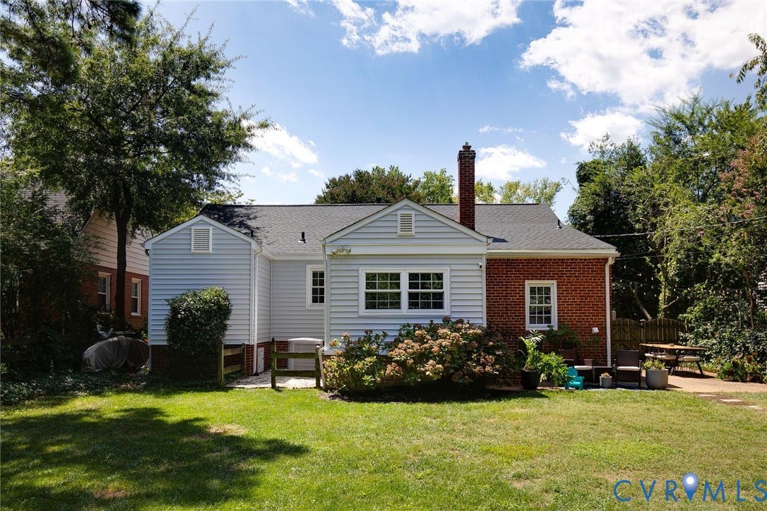4710 Park Avenue, Mary Munford / Near West End, Richmond, VA 23226 Exterior of home featuring light-colored horizontal siding, red brick accents, an asphalt shingle roof, a masonry chimney, and a stone patio