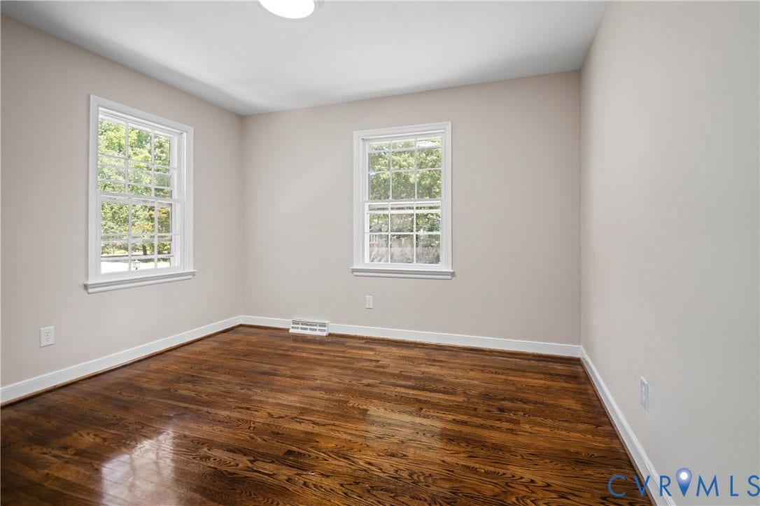 9010 Fawn Lane, Henrico, VA 23229 Neutral-toned interior room featuring wood-finish flooring and two double-hung windows with grid detailing