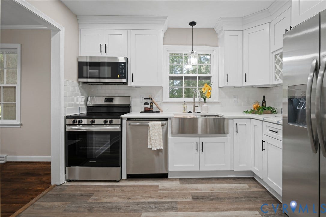 9010 Fawn Lane, Henrico, VA 23229 Kitchen featuring white shaker-style cabinetry, stainless steel farmhouse sink, white subway tile backsplash, stainless steel appliances, and wood-finish flooring