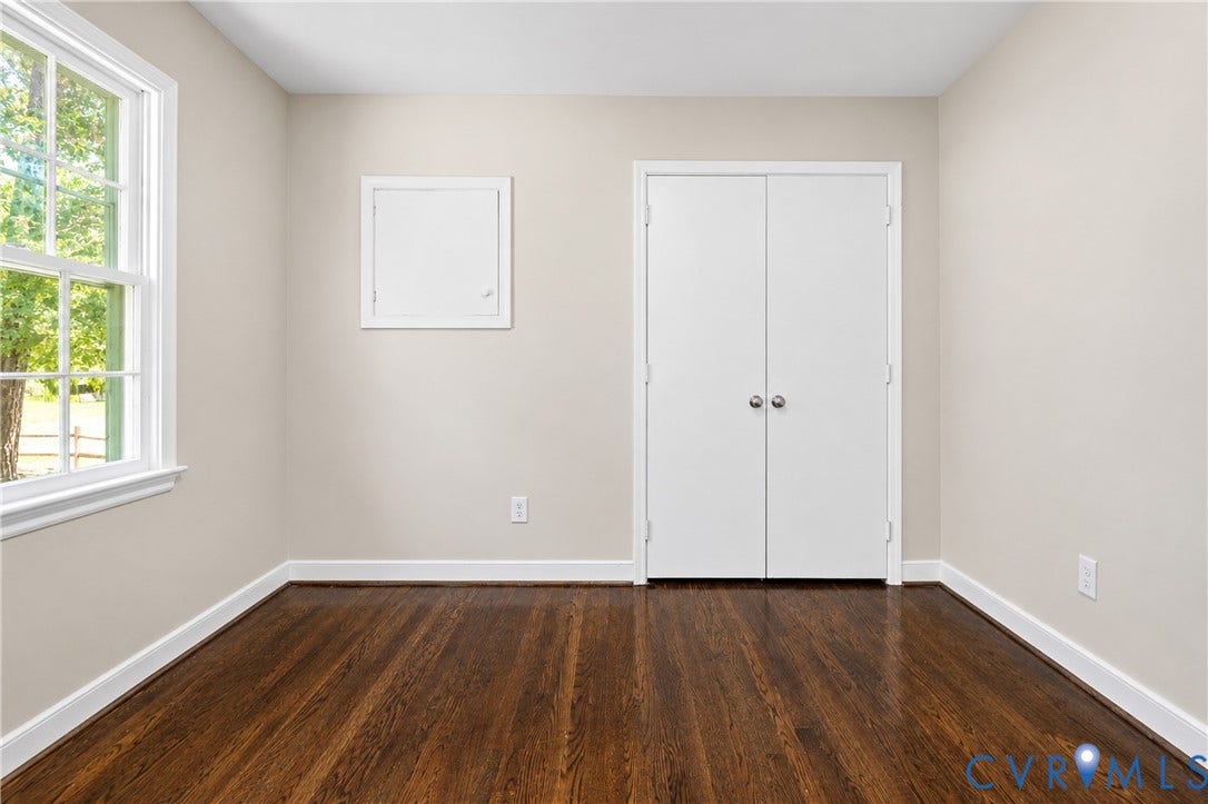 9010 Fawn Lane, Henrico, VA 23229 Room featuring wood-finish flooring, a double-door closet, and a multi-pane window with a white frame