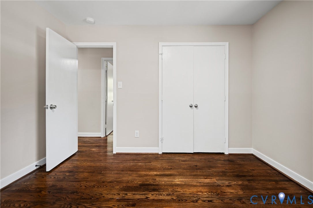 9010 Fawn Lane, Henrico, VA 23229 Room featuring dark wood-finish flooring, neutral walls, and dual-door closet with spherical knobs