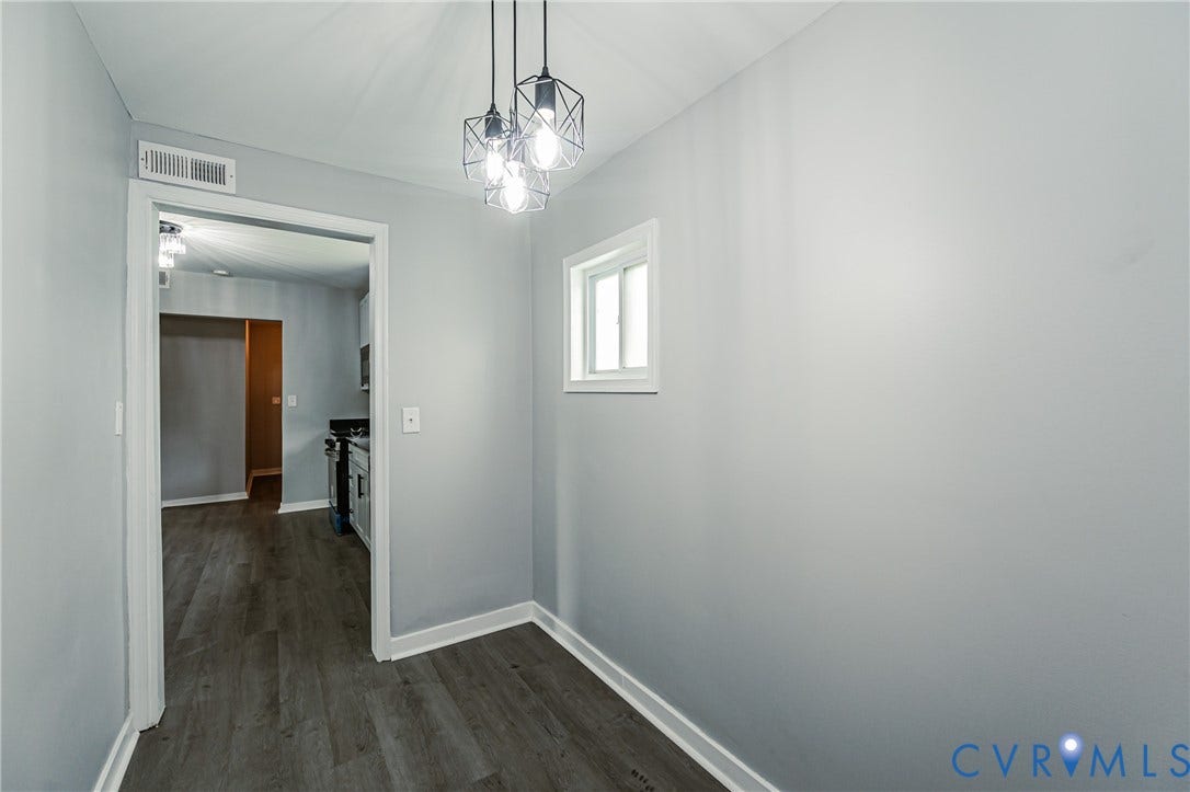 Wood-finish flooring, geometric-frame pendant lighting, and a single-pane sliding window
