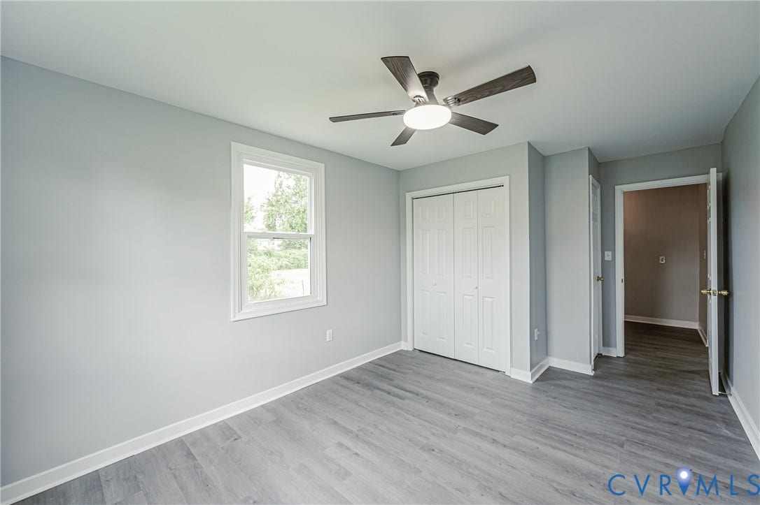 Room featuring wood-finish flooring, a double-panel closet with white doors, a ceiling fan with integrated lighting, and a single-hung window