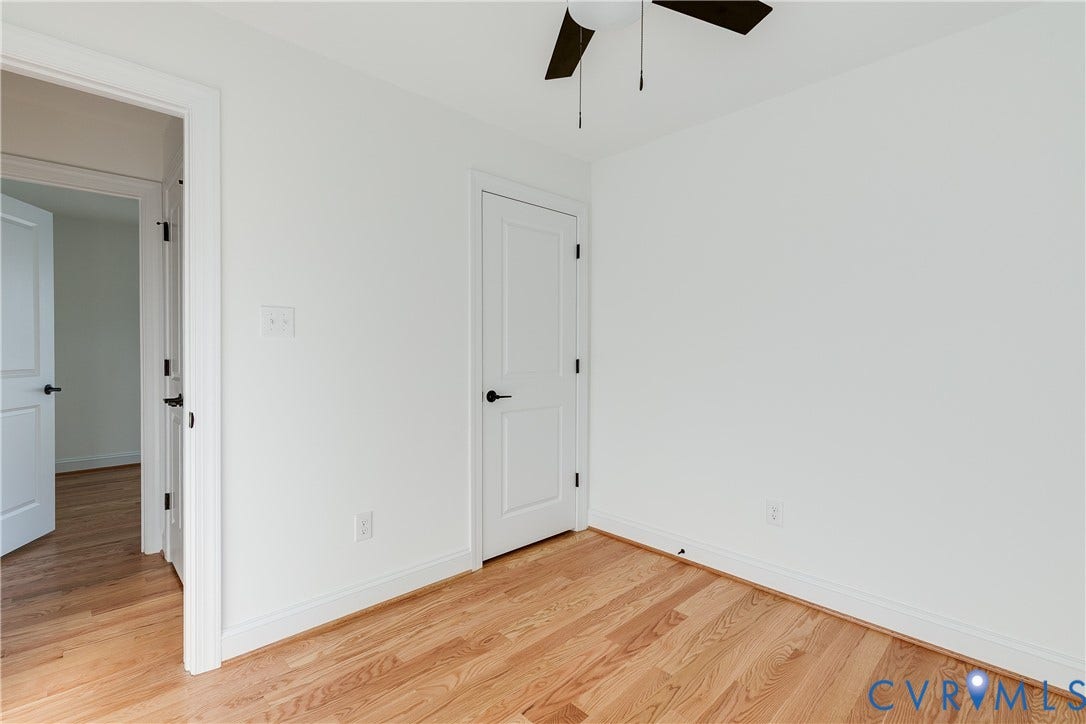 637 Ellens Haven Alley, Highland Grove, Richmond, VA 23222 Wood-finish flooring, two-panel interior doors with matte black hardware, and a ceiling-mounted fan with integrated lighting