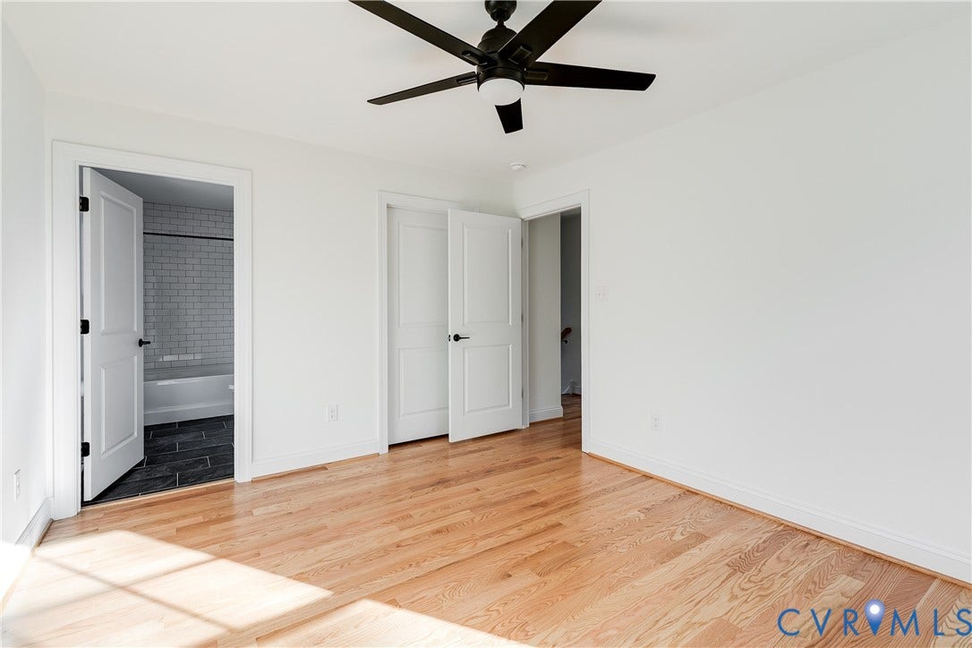 637 Ellens Haven Alley, Highland Grove, Richmond, VA 23222 Interior space featuring wood-finish flooring, a matte black ceiling fan with integrated lighting, and multi-panel interior doors with matte black hardware