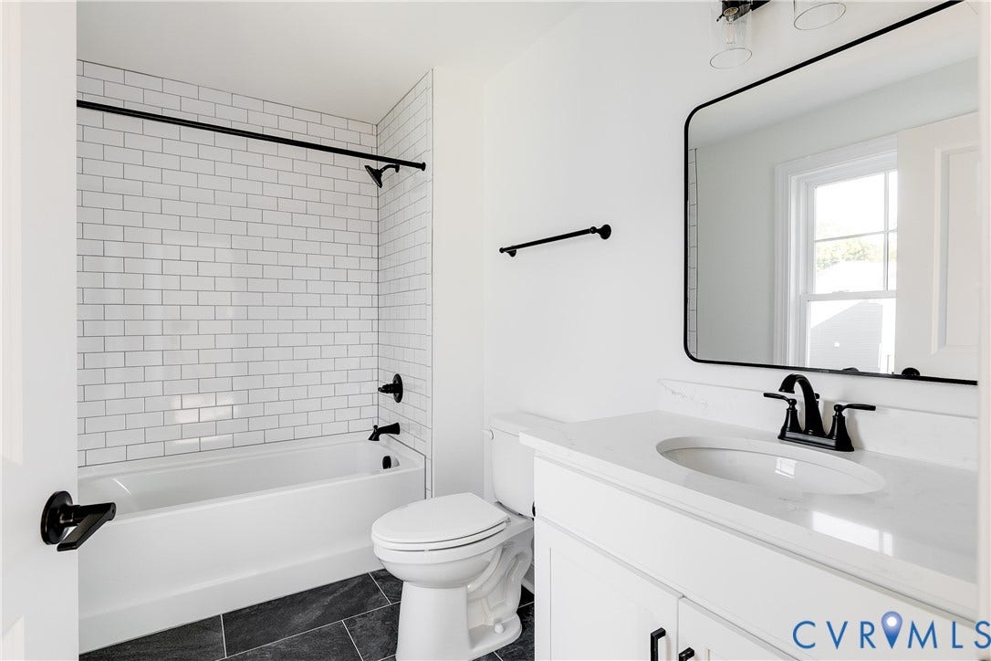 637 Ellens Haven Alley, Highland Grove, Richmond, VA 23222 Bathroom featuring a tub-shower combination with white subway tile surround, vanity with a white countertop and oval undermount sink, matte black hardware, and dark tile flooring