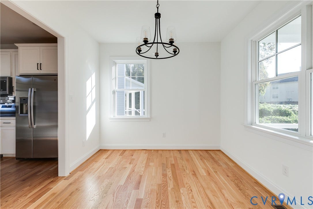637 Ellens Haven Alley, Highland Grove, Richmond, VA 23222 Dining area featuring wood-finish flooring, multi-pane windows, and a black-finish metal chandelier
