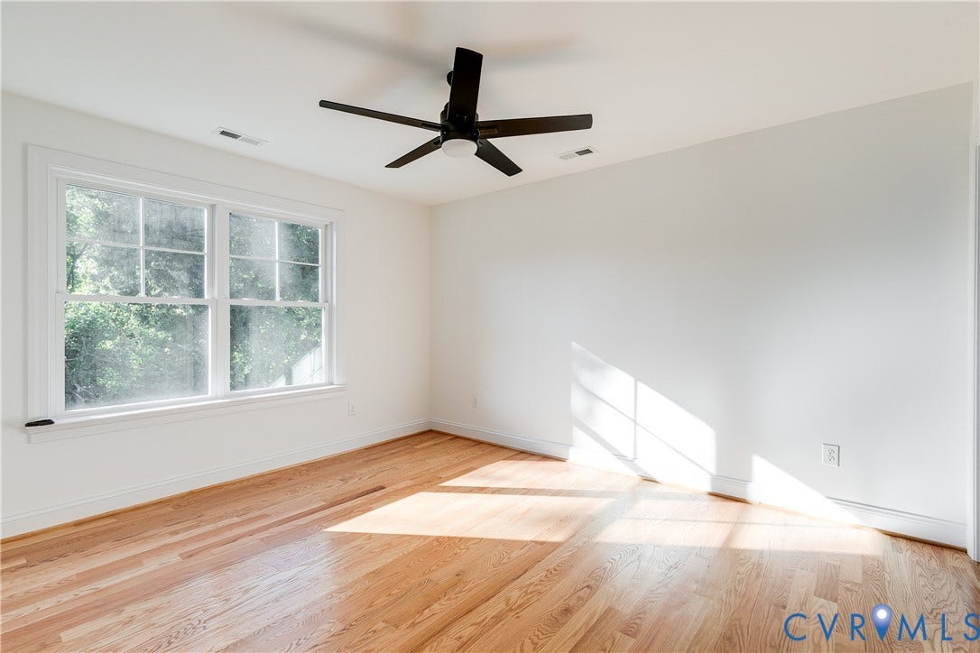 637 Ellens Haven Alley, Highland Grove, Richmond, VA 23222 Interior space featuring wood-finish flooring, a matte black multi-blade ceiling fan with integrated lighting, and a double-hung window with muntins