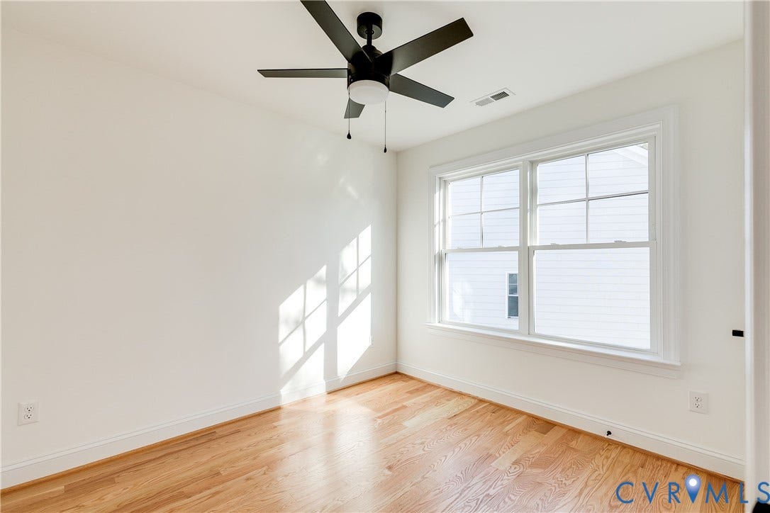 637 Ellens Haven Alley, Highland Grove, Richmond, VA 23222 Room featuring wood-finish flooring, a matte black ceiling fan with an integrated light fixture, and double-hung windows with muntin bars