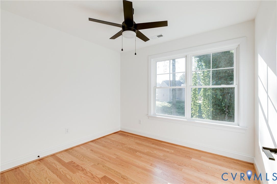 637 Ellens Haven Alley, Highland Grove, Richmond, VA 23222 Room featuring wood-finish flooring, white walls, double-pane window with grid muntins, and a ceiling-mounted fan with integrated light