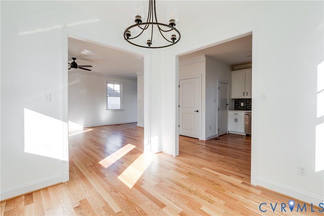 637 Ellens Haven Alley, Highland Grove, Richmond, VA 23222 Wood-finish flooring, matte black five-light chandelier, recessed interior doorways, and white shaker-style cabinetry with tile backsplash