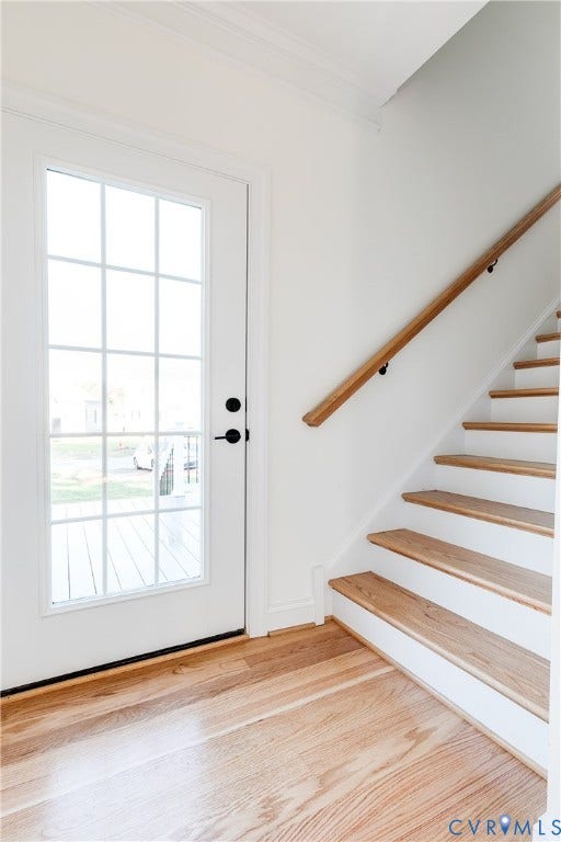 637 Ellens Haven Alley, Highland Grove, Richmond, VA 23222 Entryway featuring a full-light glass panel door with matte black hardware, wood-finish flooring, and a staircase with wood treads and a matching wood handrail