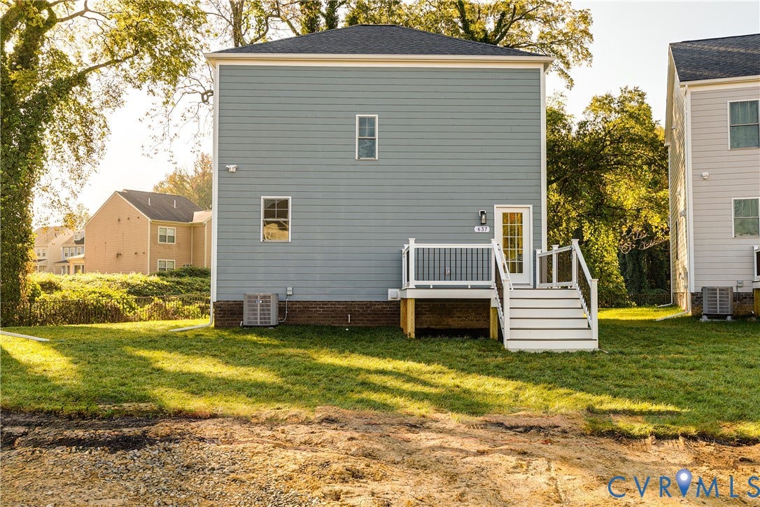 637 Ellens Haven Alley, Highland Grove, Richmond, VA 23222 Two-story residence featuring light blue horizontal siding, a masonry foundation, and an elevated deck with white railings and stairs