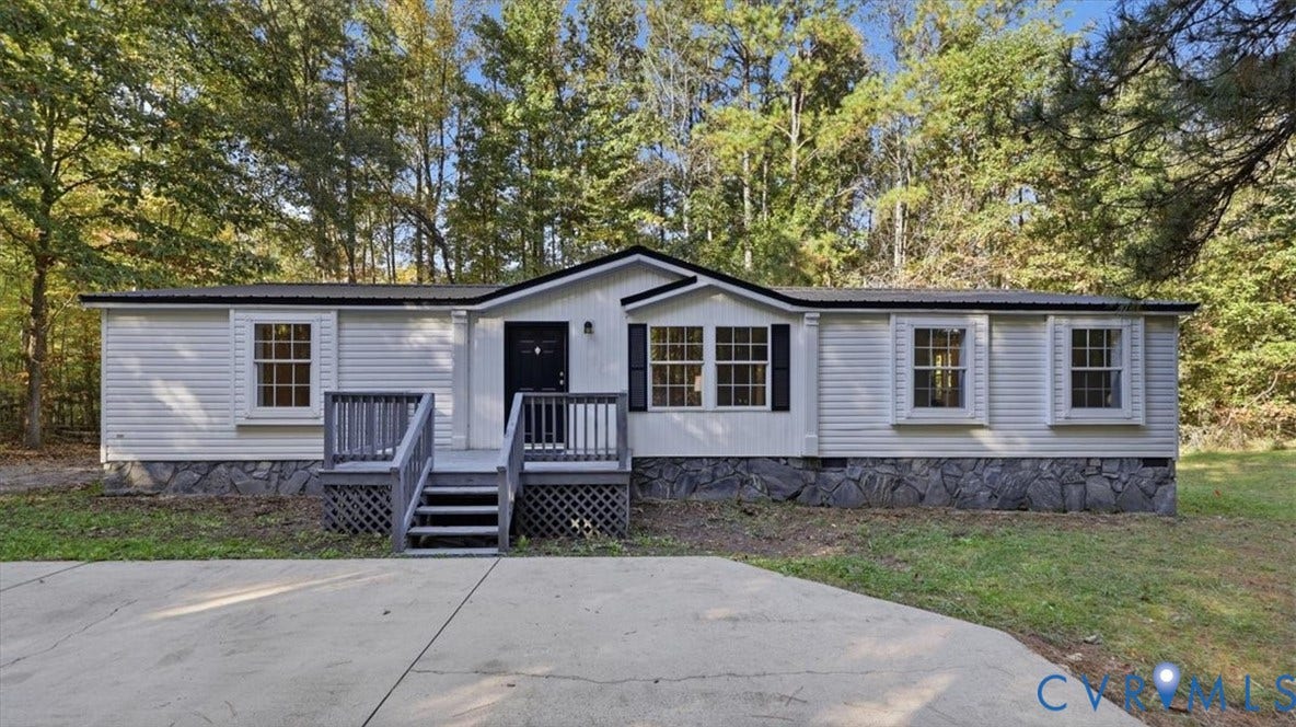 75 Claybank Road, Cumberland, VA 23040 Single-story exterior featuring light-colored horizontal siding, a stone veneer foundation, dark-trimmed window shutters, a front wooden deck with stairs, and a concrete driveway